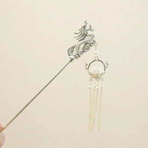 Detail of silver dragon hair pin with elegant white pearls and long hanging tassels