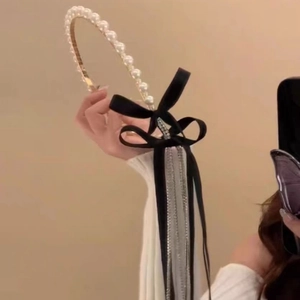 Detail view of velvet bow headband with pearls, rhinestones, and long elegant tassels