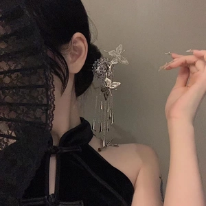 Detail of silver butterfly tassel hairpin styled with a black qipao for vintage elegance