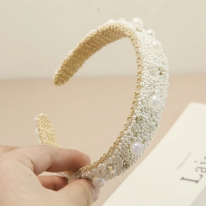 Close-up of a wide baroque headband featuring intricate pearls and sparkling rhinestones
