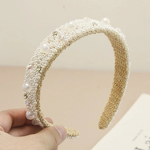 Close-up of wide baroque headband with white imitation pearls and sparkling crystals