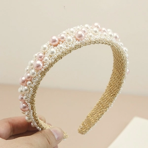 Detail of handmade baroque headband with pink pearls on a gold woven metal base