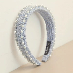 Detailed macro view of blue tweed knitted headband with hand-sewn pearls and sequins