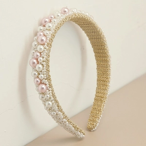 Detail of handmade baroque headband with pink and white pearls on gold braided base