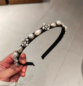 Detail of elegant pearl headband featuring white pearls and rhinestone flower clusters