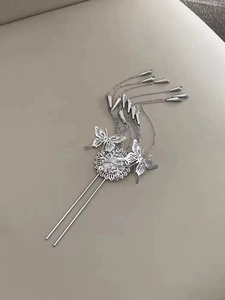 Detailed view of silver butterfly hair stick with delicate metallic fringe tassels