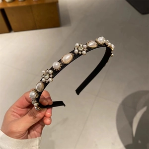 Detail of elegant black fabric headband with faux white pearls and rhinestone flowers