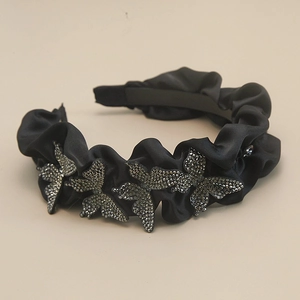 Detailed macro view of black pleated satin headband with rhinestone butterfly ornaments