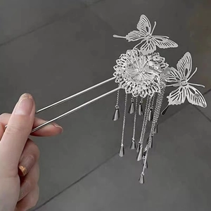 Close-up of silver butterfly hair stick with delicate tassels and floral hollow details