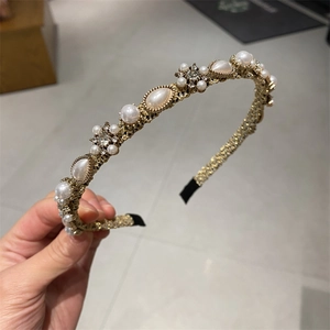 Detail of elegant gold alloy headband with pearls, rhinestones and floral cluster design