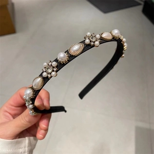Detail of elegant black headband with white pearls and sparkling rhinestone floral patterns
