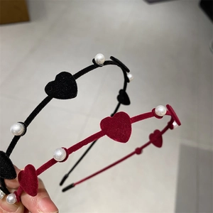 Close-up of velvet headband with delicate red hearts and white pearls texture