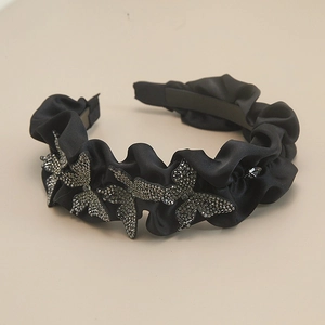 Detail of ruched black satin headband featuring luxury rhinestone butterfly accents