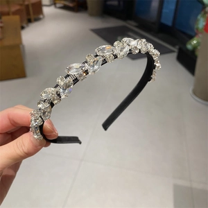 Close-up of luxury leaf rhinestone headband with silver crystals and prong setting detail