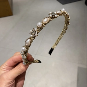 Detailed shot of the woven gold headband featuring pearls and sparkling rhinestones