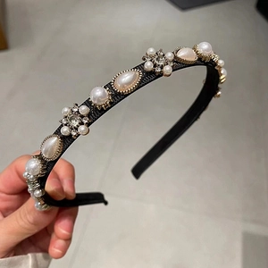 Detailed close-up of a French style headband featuring faux pearls and sparkling rhinestones