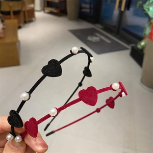 Detail of red heart flocking and faux pearls on a slim elegant velvet headband