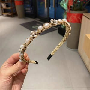Detail of handcrafted gold metal headband with faux pearls and sparkling rhinestones