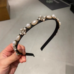 Close-up of elegant black headband with assorted faux pearls and floral rhinestones
