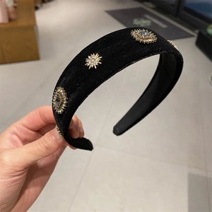 Retro black velvet headband with golden sunflower rhinestone accents in wide-brim style