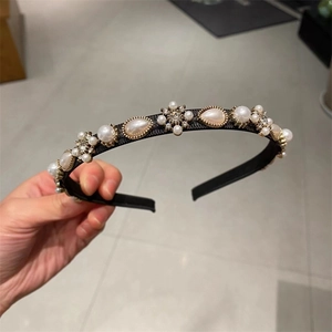 Close-up of pearl and crystal embellishments on elegant black French hairband