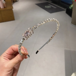 Detail of crystal headband featuring a rectangular pink gemstone and silver metal frame