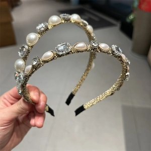 Detailed close-up of retro gold hairbands with inlaid white pearls and square crystals