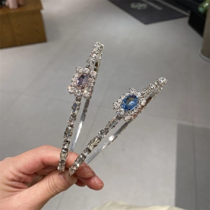 Detail of luxury rhinestone headband featuring blue and pink crystals on silver-plated metal