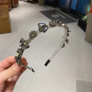 Elegant silver metal leaf headband featuring sparkling grey and olive green crystals