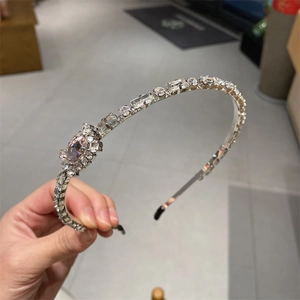 Detail of silver crystal headband featuring geometric rhinestones and protective end tips