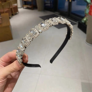 Close-up of large emerald-cut crystals with micro-pave rhinestones on a black headband