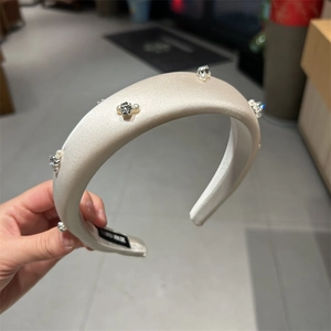 Detail of handmade champagne satin padded headband with pearls and sparkling crystals