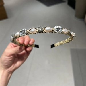 Dettaglio del cerchietto retrò dorato con perle a goccia e cristalli geometrici scintillanti