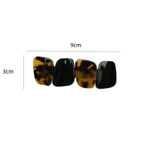Detail showing elegant tortoiseshell and black hair clip dimensions of 9cm by 3cm