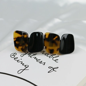 Elegant tortoiseshell and black acrylic hair clip on silk fabric detail view