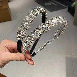 Detailed view of two luxury rhinestone headbands with leaf patterns in black and silver base