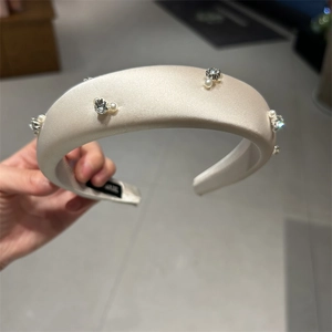 Detail of satin padded headband with pearls and rhinestones on high-quality fabric