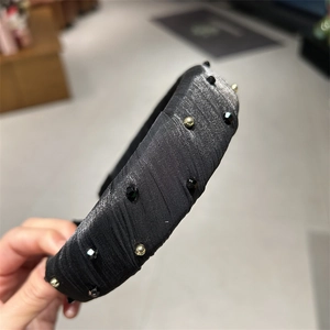 Serre-tête élégant en tissu plissé noir orné de cristaux et de perles dorées