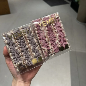 Gros plan de chouchous dentelle ondulés violet et rose dans des boîtes transparentes