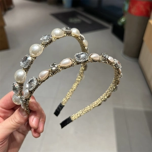 Dettaglio di un cerchietto vintage con perle, cristalli quadrati e base in metallo dorato
