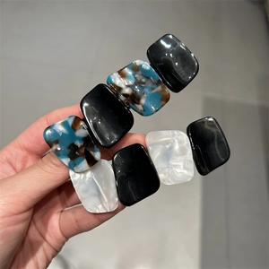 Close-up of tortoise shell and marble pattern acetate hair clip set with metal base