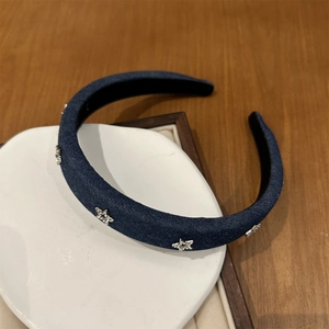 Vue détaillée d'un serre-tête en denim bleu foncé avec des ornements d'étoiles en zircon