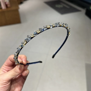 Exquisite navy blue crystal headband with hand-held showcase in a retail setting