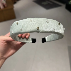 Détails du serre-tête en tissu vert menthe orné de perles de cristal et d'accents dorés