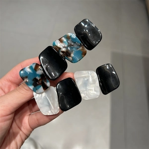 Close-up of rectangular acetate hair clips with tortoiseshell and marble patterns