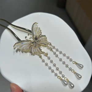 Detailed macro view of a golden butterfly hair pin with pearls and tassels for women