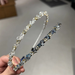 Close-up of fine rhinestone headband featuring clear crystals and grey blue crushed stones