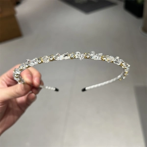 Macro detail of headband featuring white braided fabric and shimmering crushed crystals