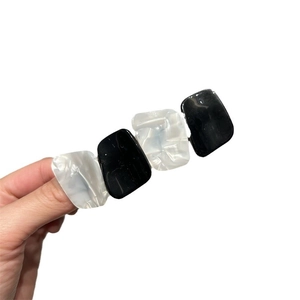 Elegant geometric hair clip with black and marble white resin plates in a minimalist design