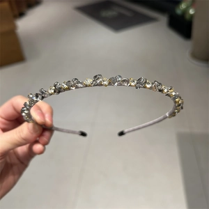 Detailed macro view of purple fabric headband with grey crystals and gold rhinestones